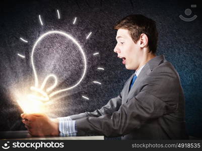 Man using laptop. Young businessman looking shocked into tablet pc