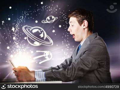 Man using laptop. Young businessman looking shocked into tablet pc