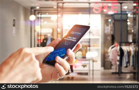 Man using mobile payments online shopping network connection on screen, Mall department store background. All on screen and credit card are design up.
