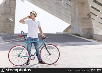 man using mobile phone and fixed gear bicycle in the street.