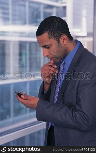 man using mobile phone in office corridor
