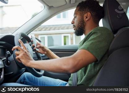 Man Using Mobile Phone Whilst Driving Car