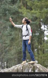 Man Using Mobile Phone Whilst Hiking In Countryside