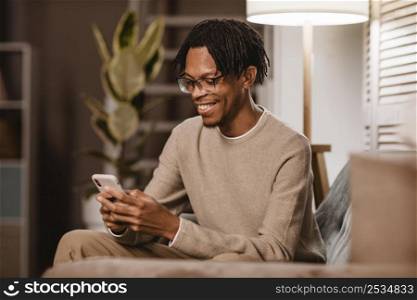 man using modern smartphone device while couch home
