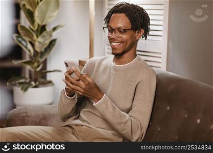 man using modern smartphone device while sofa home