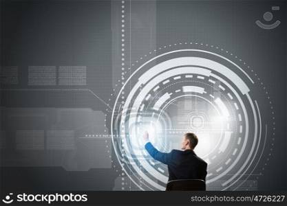 Man using modern technologies. Back view of businessman working with virtual panel