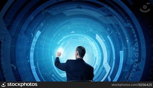 Man using modern technologies. Back view of businessman working with virtual panel