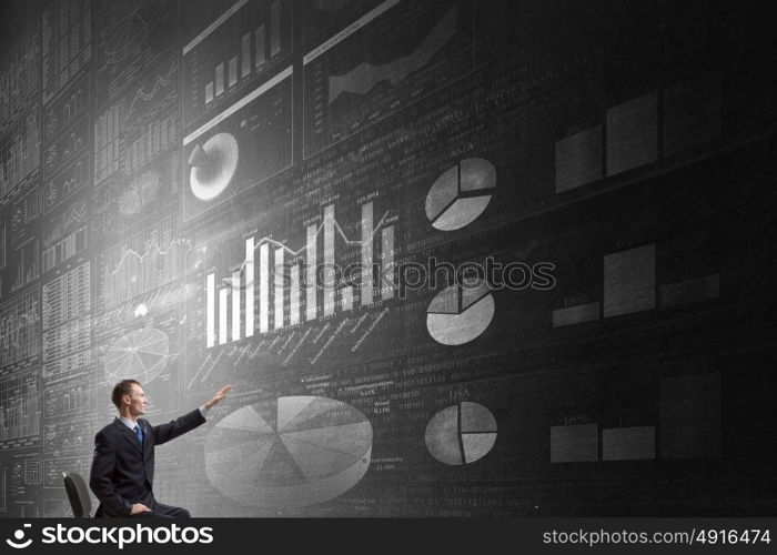 Man using modern technologies. Businessman in chair working with virtual panel