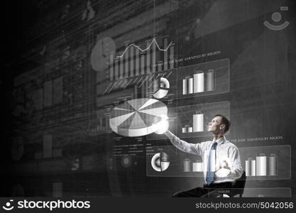 Man using modern technologies. Businessman in chair working with virtual panel