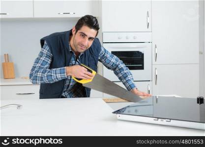 Man using saw in kitchen