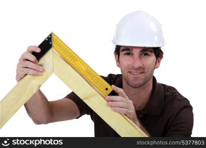 Man using setsquare on wooden frame