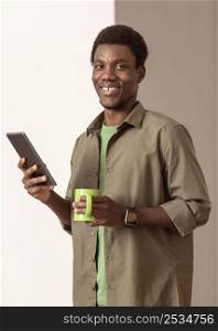 man using smartphone holding mug
