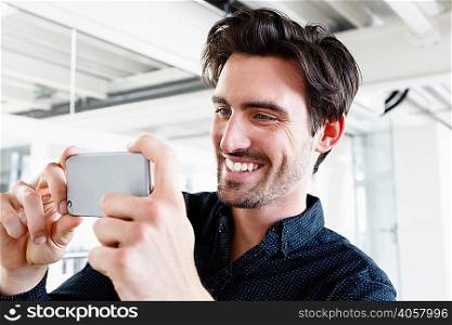 Man using smartphone to take photograph