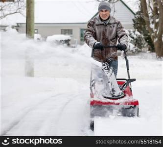 Man using snowblower in deep snow. Man using snowblower to clear deep snow on residential driveway after heavy snowfall