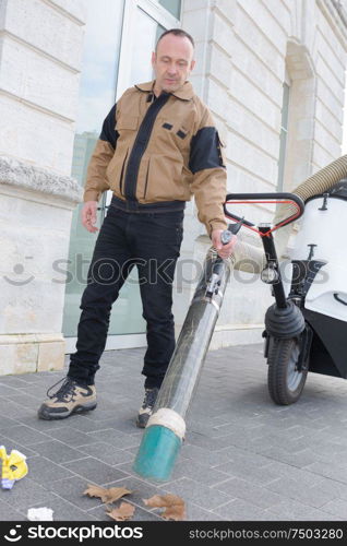 man using suction machine to clean city streets