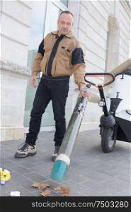 man using suction machine to clean city streets
