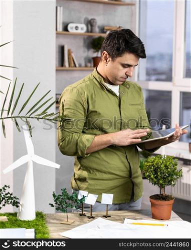 man using tablet eco friendly wind power project layout