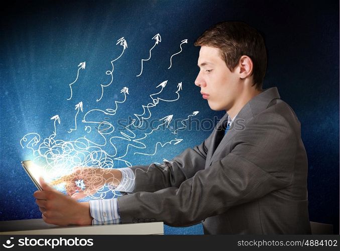 Man using tablet pc. Young emotional businessman looking in tablet pc