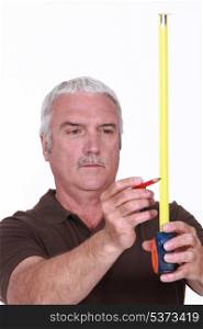 Man using tape measure and pencil