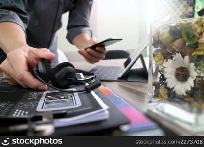 Man using VOIP headset with digital tablet computer docking keyboard,smart phone,concept communication, it support, call center and customer service help desk,vase flowers on wooden table