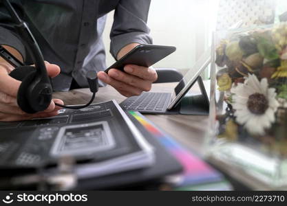 Man using VOIP headset with digital tablet computer docking keyboard,smart phone,concept communication, it support, call center and customer service help desk,vase flowers on wooden table