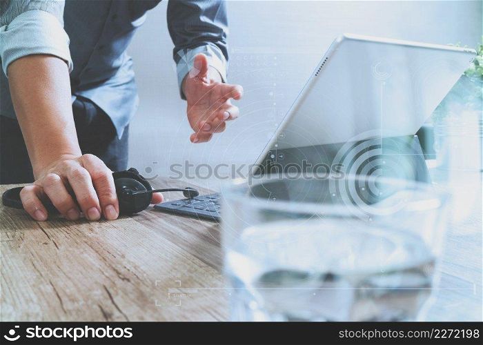 Man using VOIP headset with digital tablet computer docking smart keyboard, concept communication, it support, call center,digital screen graphic virtual icons,graph,diagram