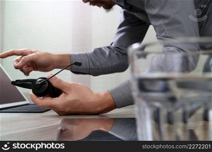 Man using VOIP headset with digital tablet computer docking smart keyboard, concept communication, it support, call center and customer service help desk