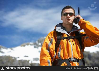Man using walkie-talkie on mountain peak