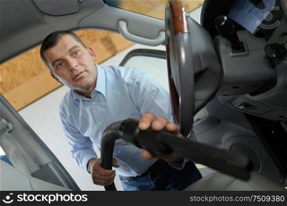 Man vacuuming inside vehicle