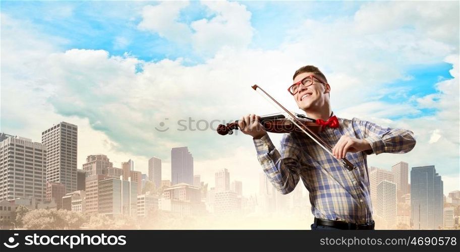 Man violinist. Young funny man in casual playing violin