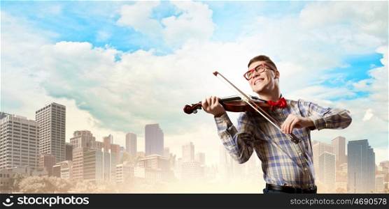 Man violinist. Young funny man in casual playing violin