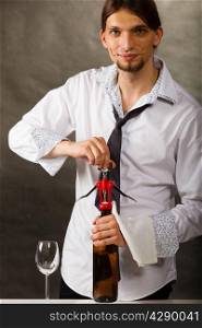 Man waiter opening bottle of wine with corkscrew