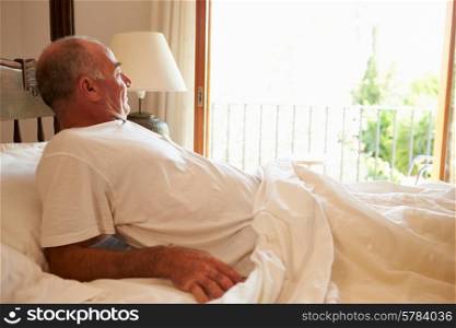 Man Waking Up In Bed In Morning