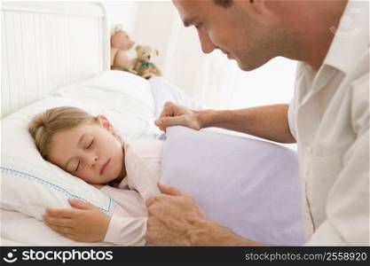 Man waking young girl in bed smiling