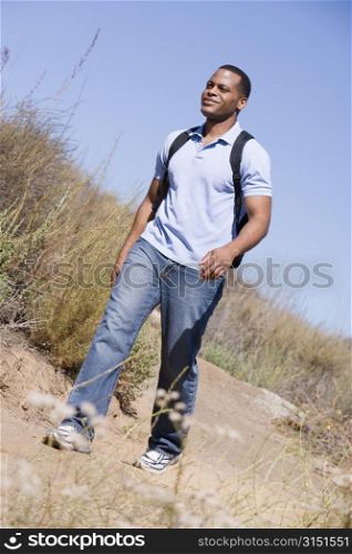 Man walking a trail in the countryside.