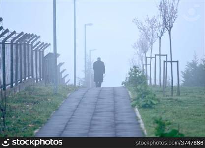 man walking alone in foggy weather