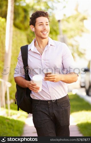Man Walking Along Street To Work Listening To Music