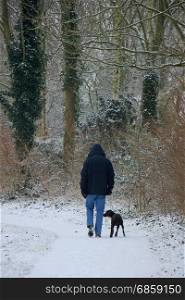 Man walking his dog in a snowy park