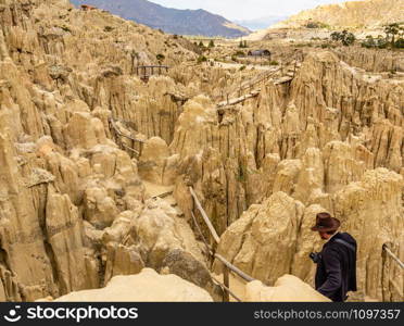 Man walking in the maze of Moon Valley or Valle De La Luna among eroded sandstone spikes, near La Paz, Bolivia