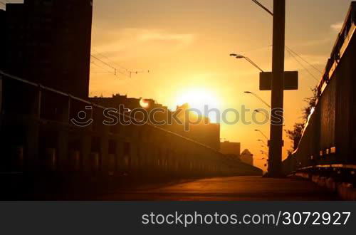 man walking on a bridge at sunset