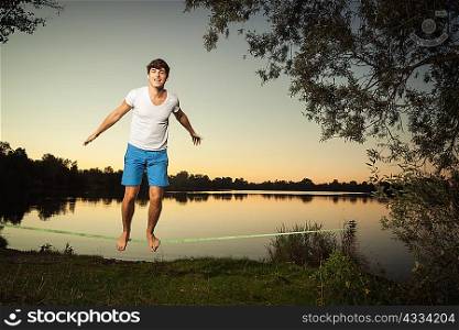 Man walking on tight rope outdoors