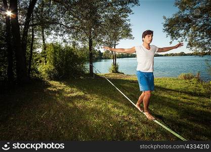 Man walking on tight rope outdoors