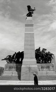 Man walking past War Memorial, Ottawa Canada.