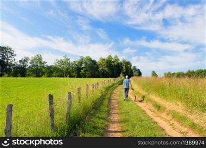 Man walking the dog in landscape green hills in French Nouvelle aquitaine