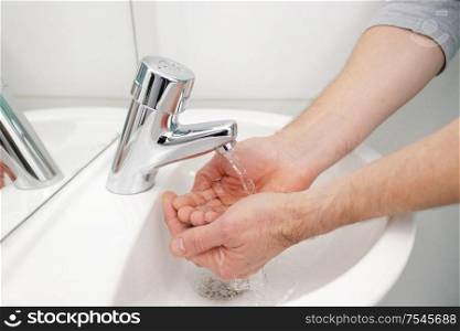 man washing hands at medical clinic sink