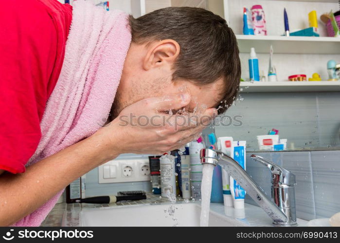 Man washing his face in the morning in the bathroom