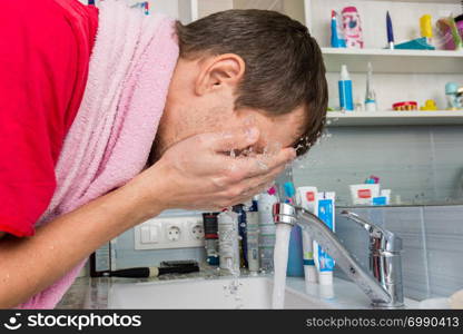 Man washing his face in the morning in the bathroom