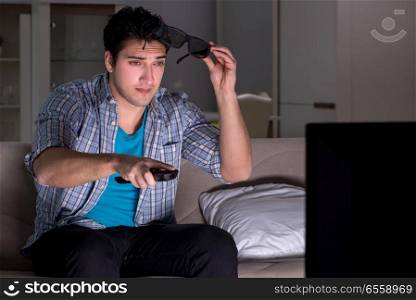 Man watching 3d television late at night