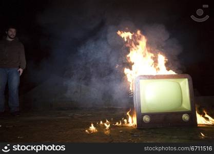 Man watching a television on fire