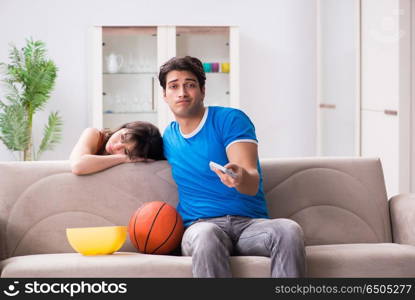 Man watching basketball with his wife